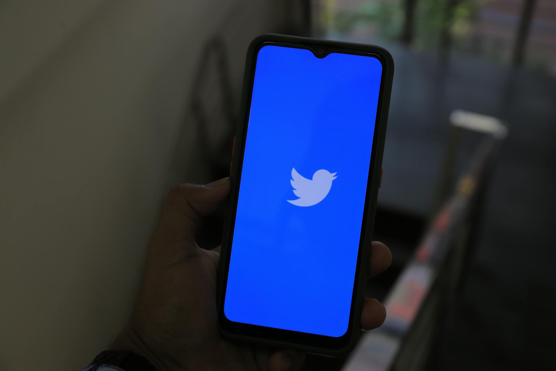 Phone displaying Twitter/X feed with video content playing inline